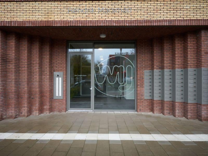 Een moderne en strak vormgegeven entree met geïntegreerde postkasten en entreepaneel.